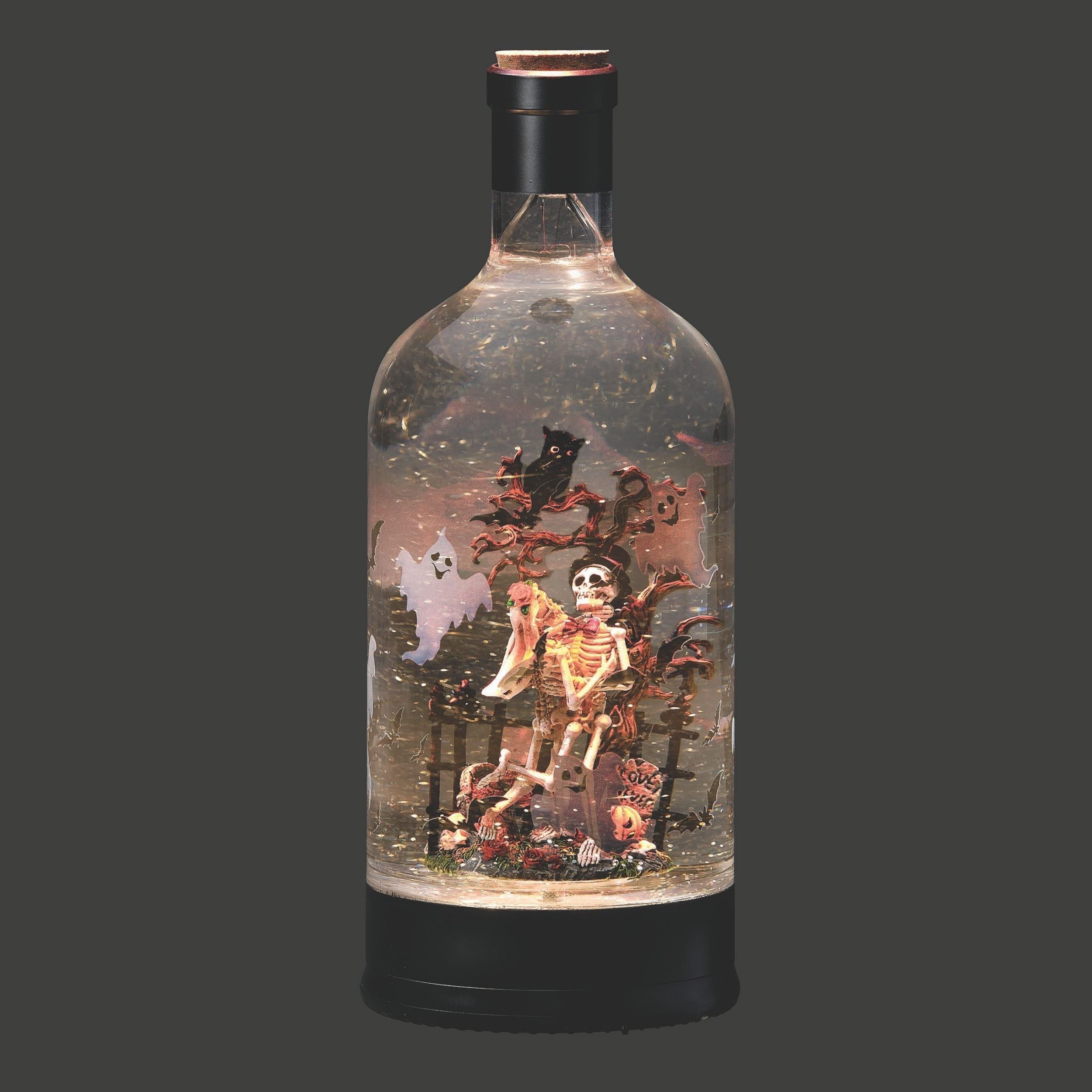 Decorative bottle with skeleton and ghost figures inside on a dark background