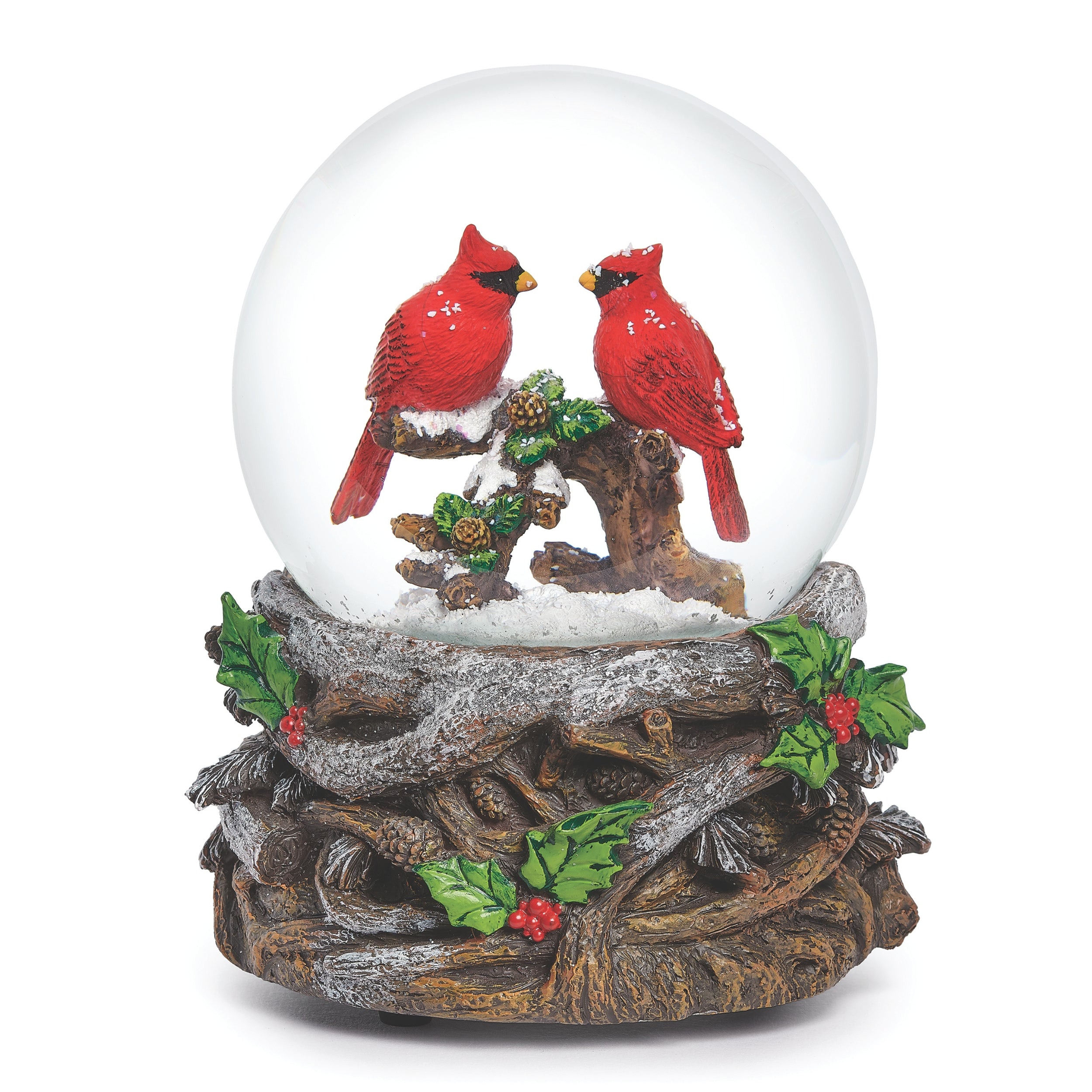 Snow globe with two red cardinals on a branch inside a clear sphere, on a decorative base with holly leaves and berries.