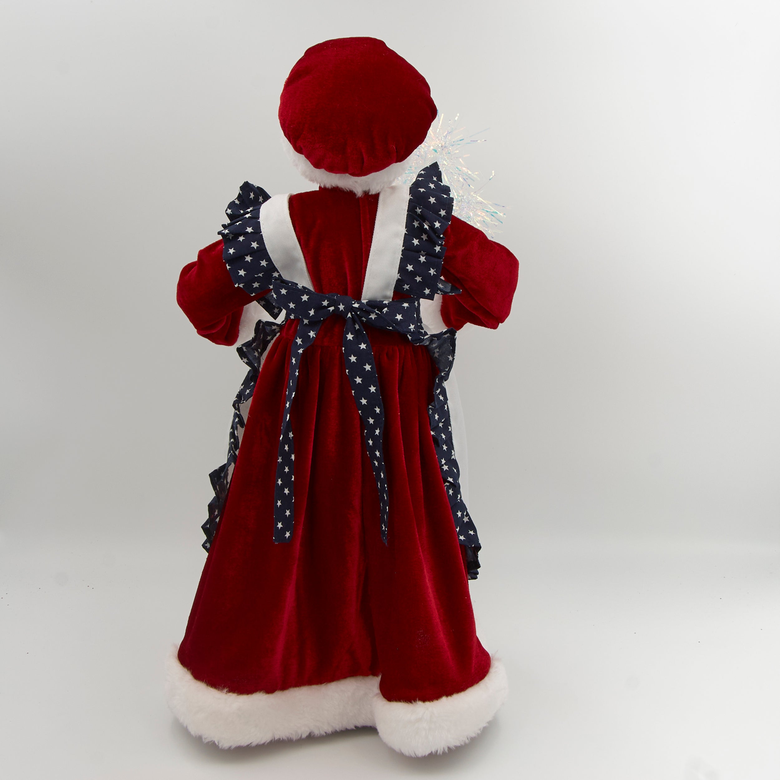 Decorative figure of a woman in a traditional outfit with a white apron and red hat, holding sparklers on a white background.