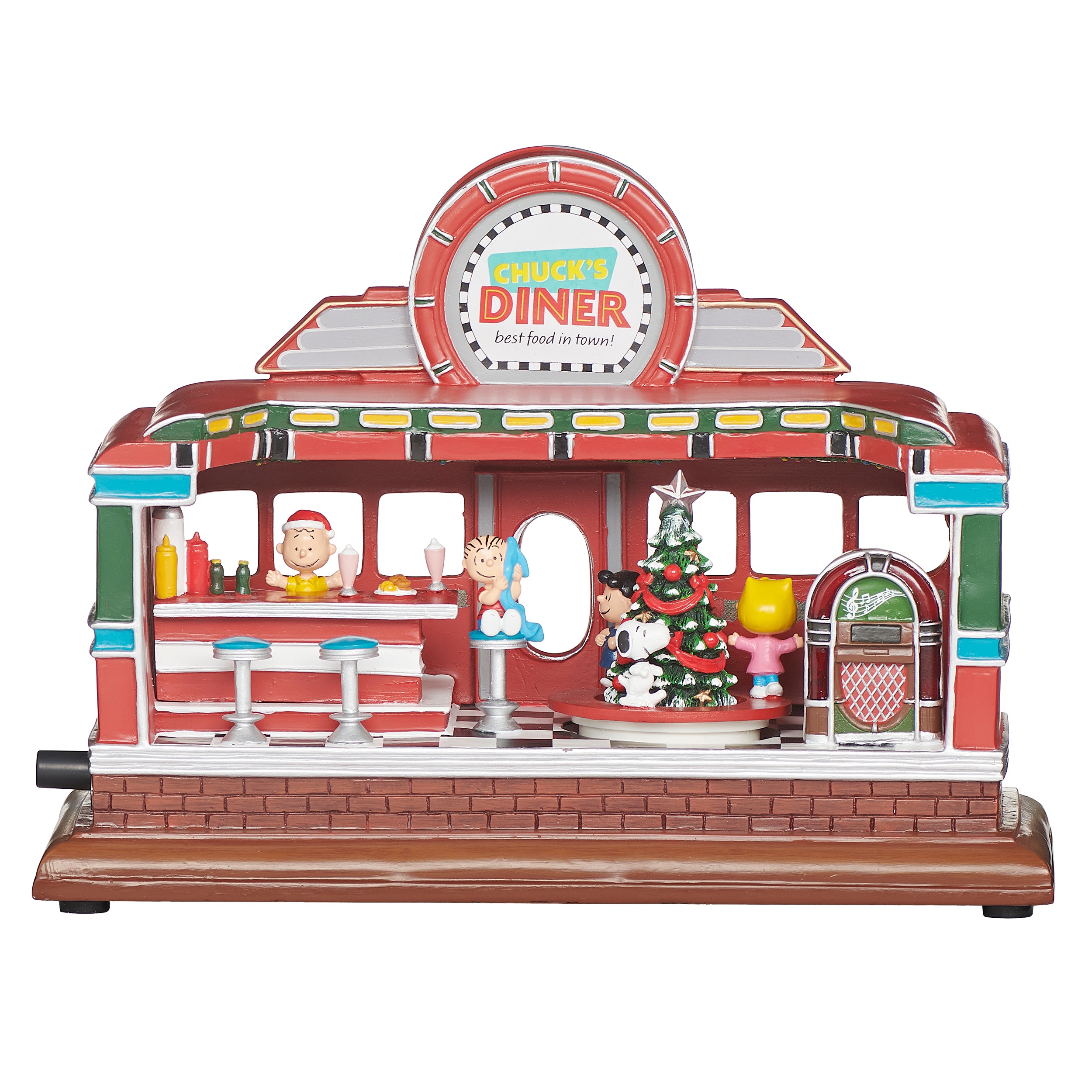 A decorative miniature toy diner set on a white background. The red and brown toy building features a circular sign reading 'Chuck's Diner' at the top, a counter, peanut characters, a green Christmas tree, and a jukebox on a brown base.