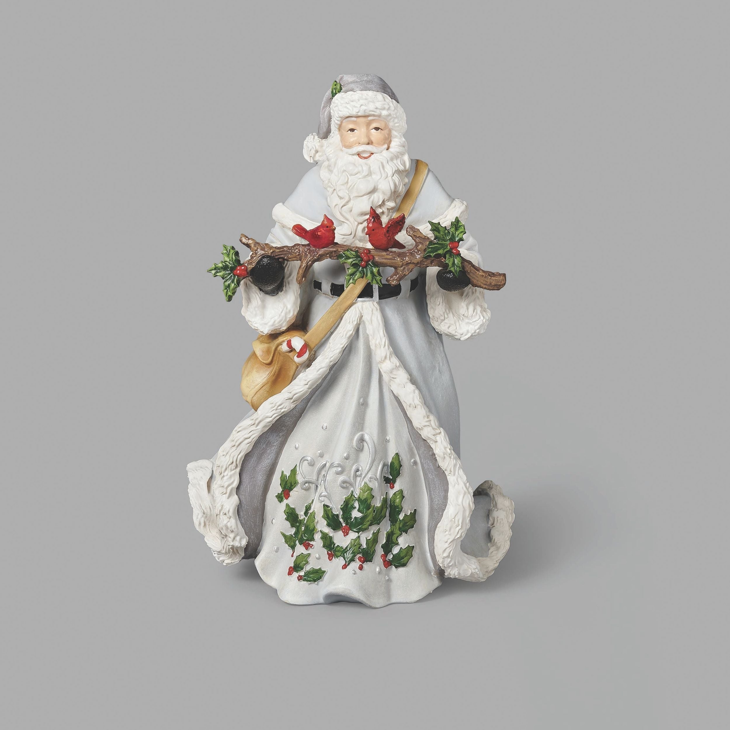 Decorative figurine of a Santa Claus holding a branch with holly and berries on a gray background