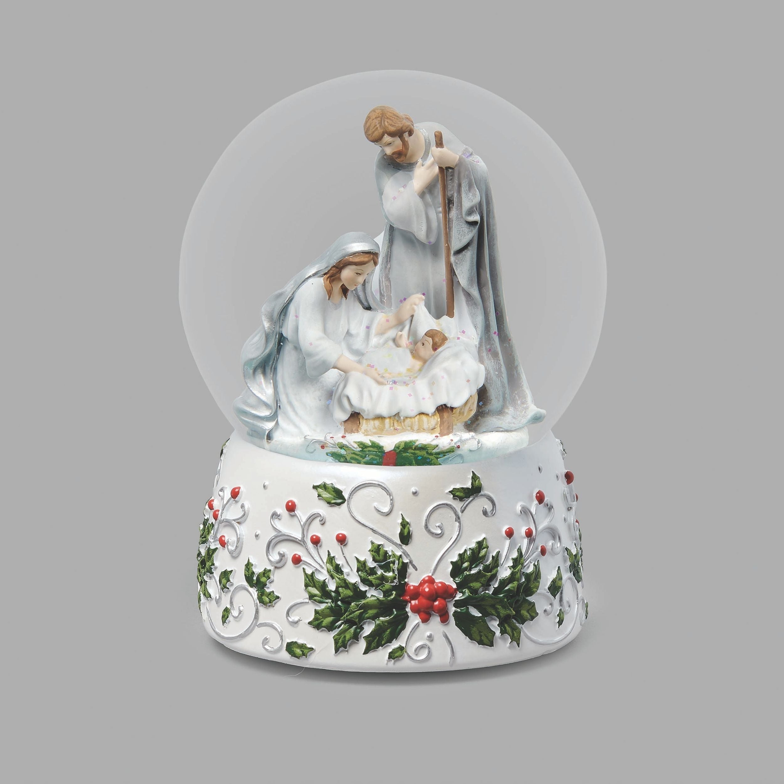 Nativity scene snow globe with figures of Mary, Joseph, and baby Jesus on a gray background