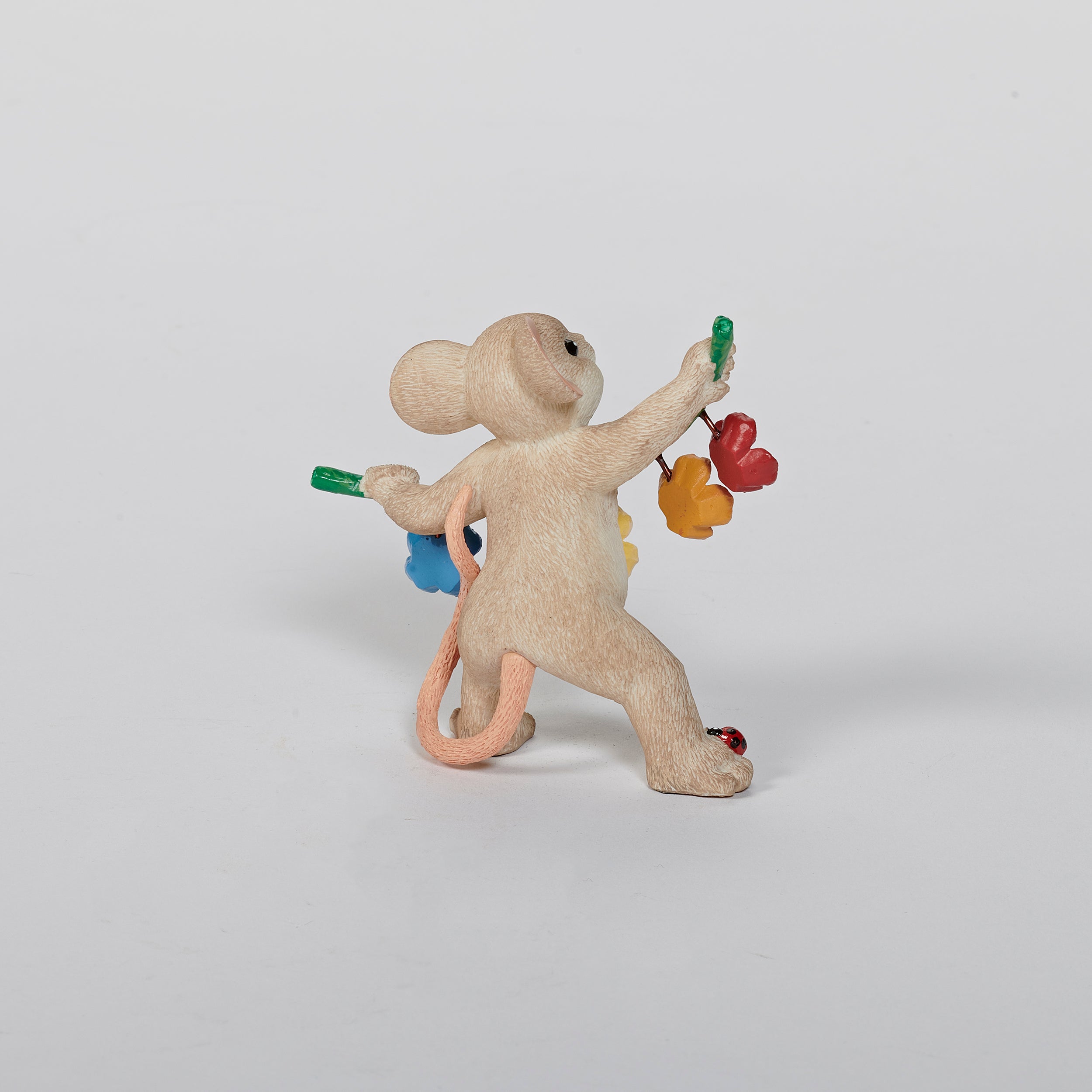 Mouse figurine with a garland spelling 'BLOOM' 