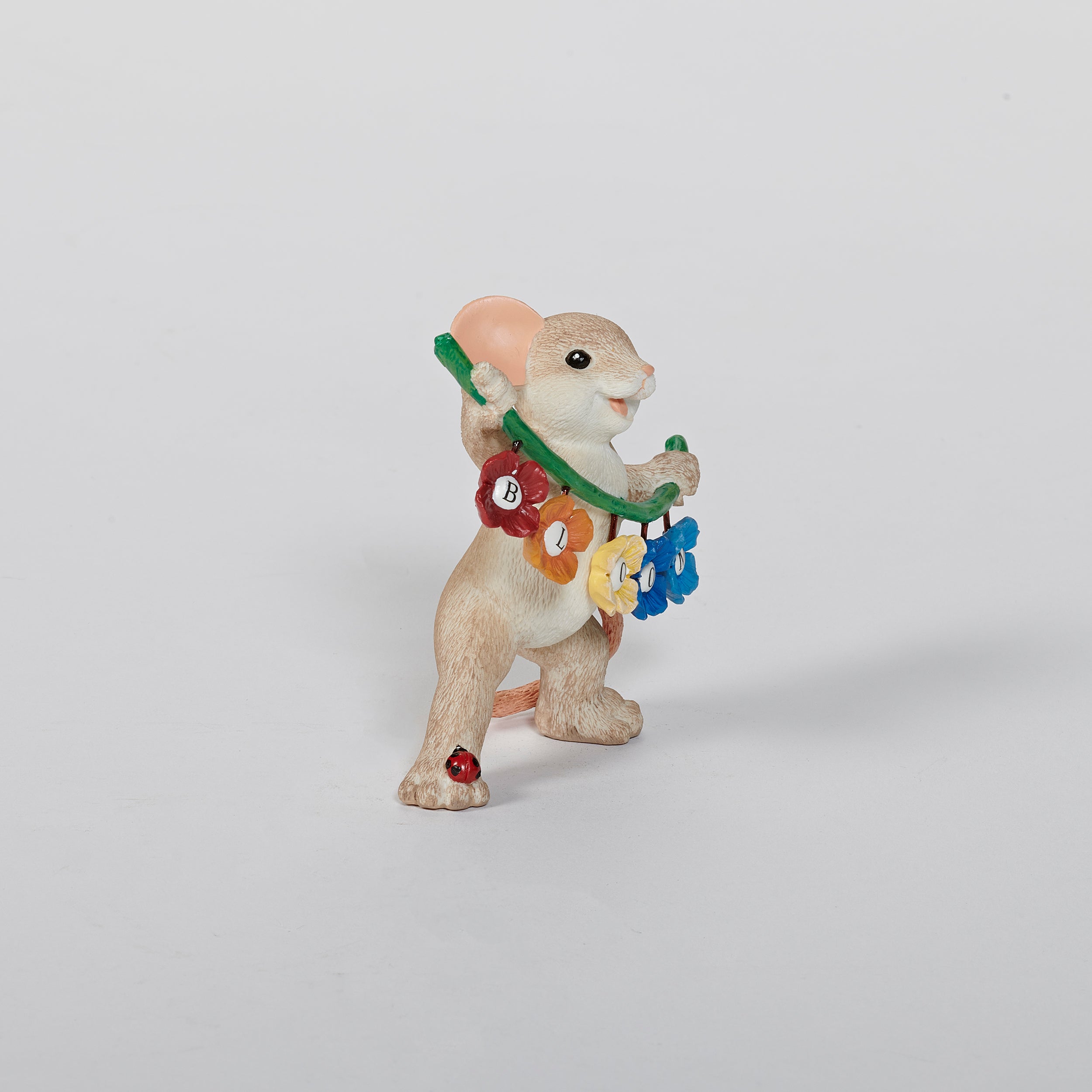 Mouse figurine with a garland spelling 'BLOOM' 