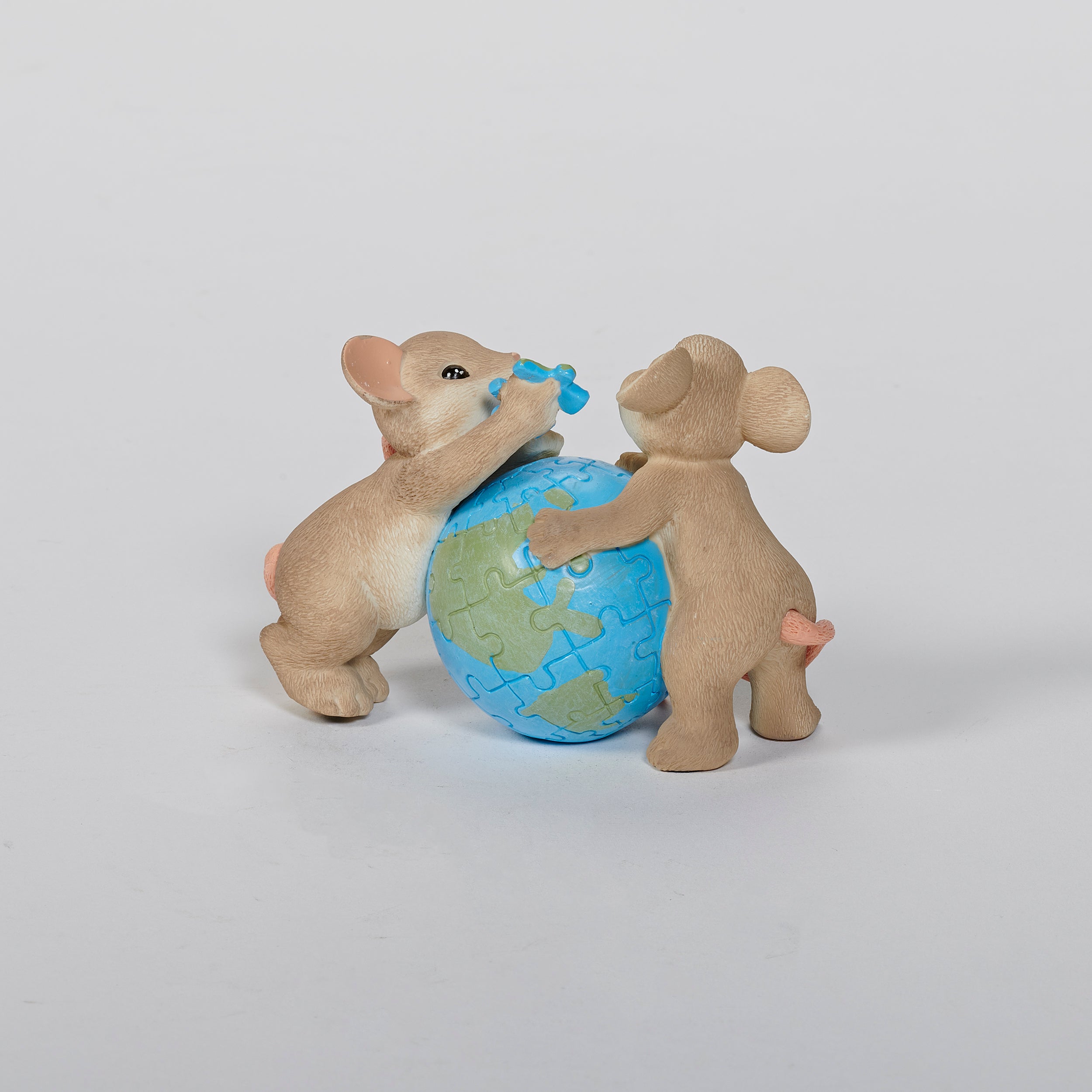 Two mouse figurines holding a globe puzzle