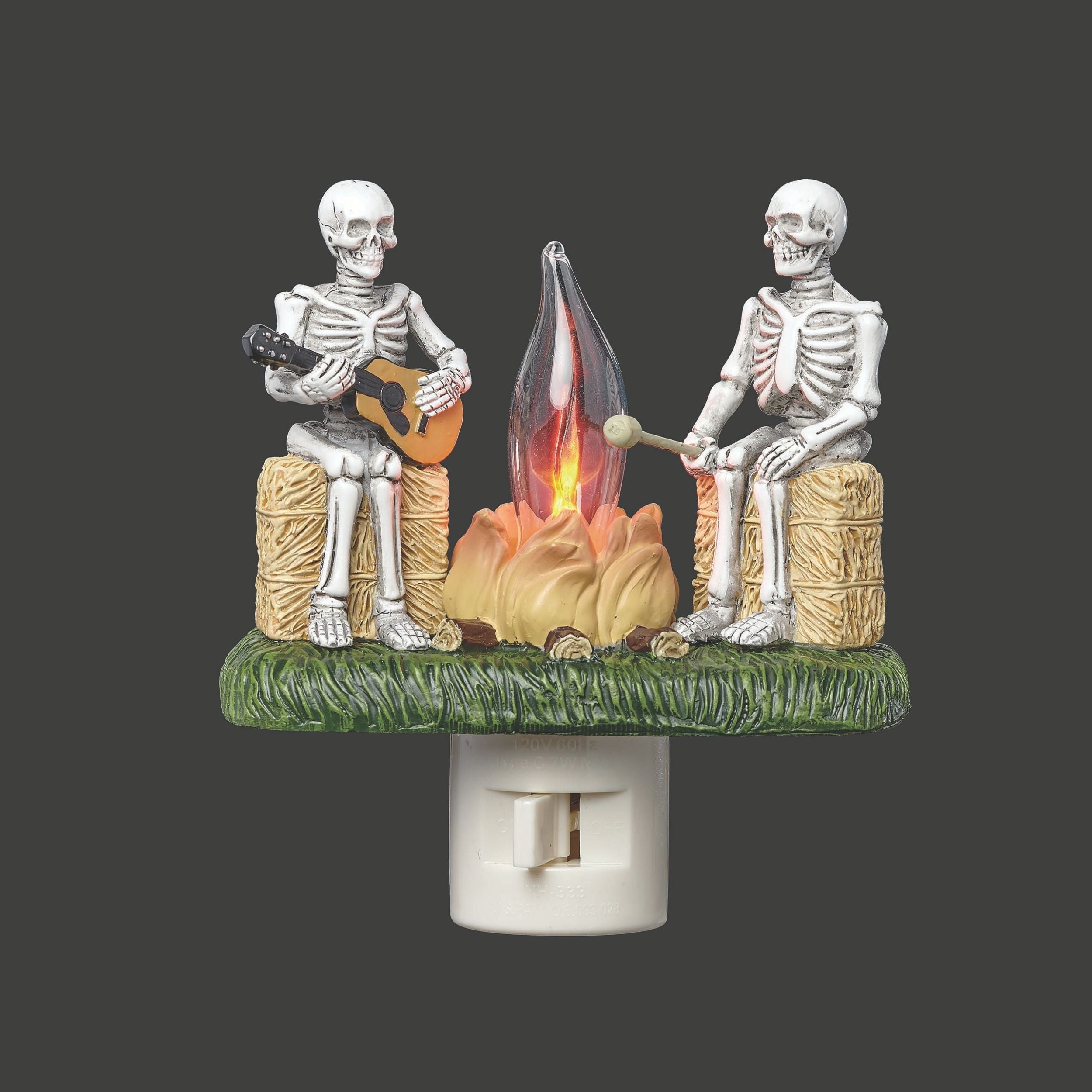 Decorative night light with skeletons around a campfire on a dark background