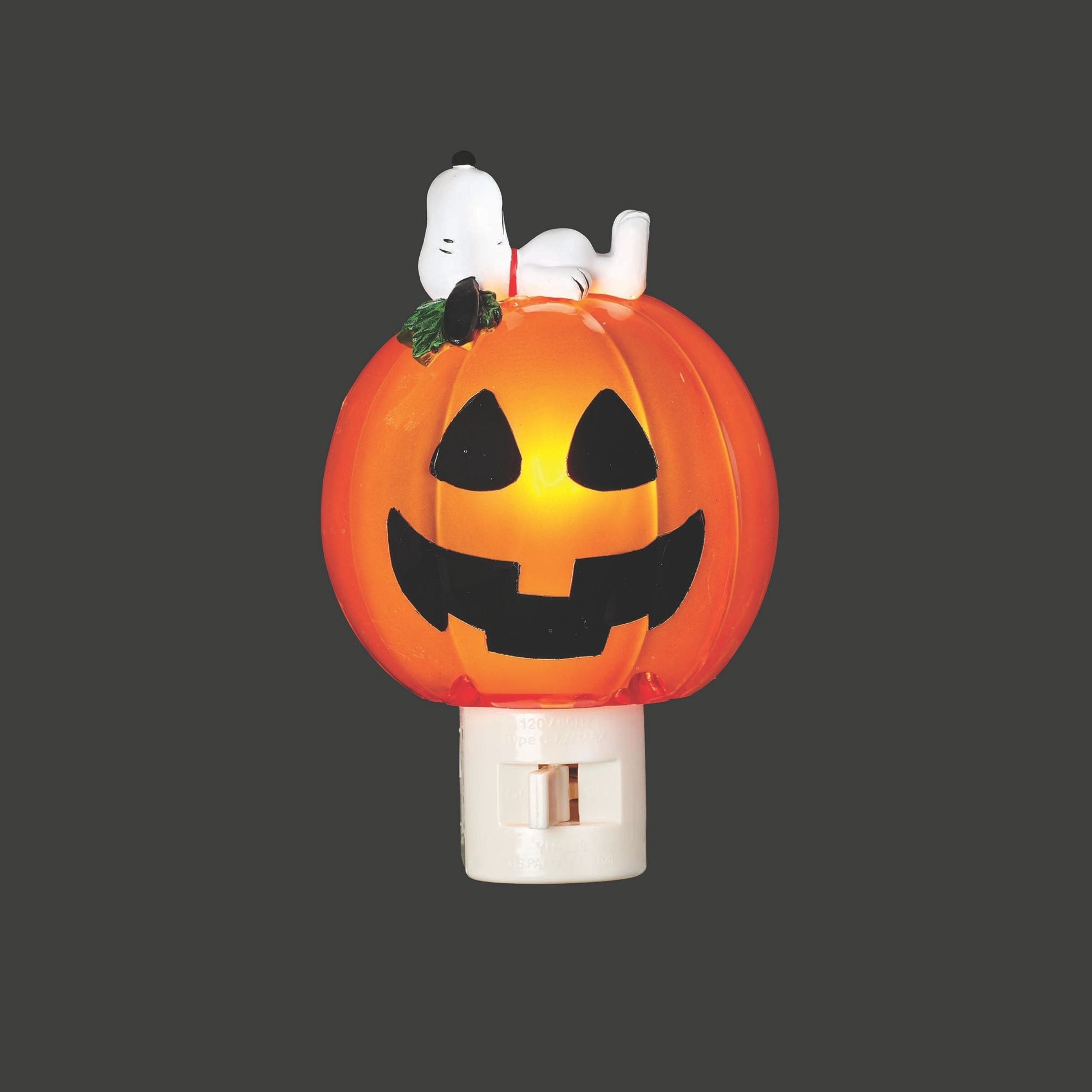 Halloween night light shaped like a jack-o'-lantern with Snoopy on top against a dark background