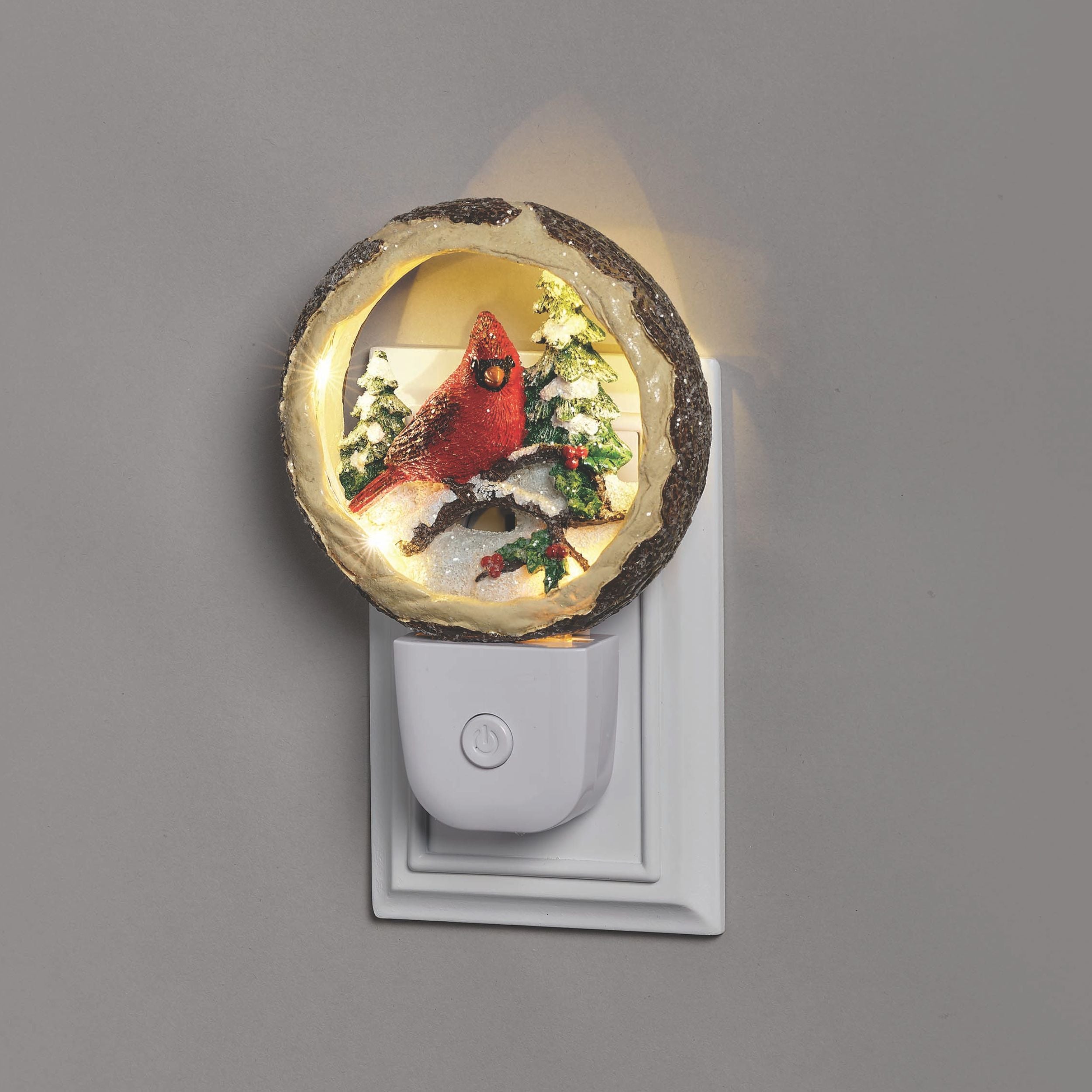 Decorative night light with a cardinal design on a gray wall.