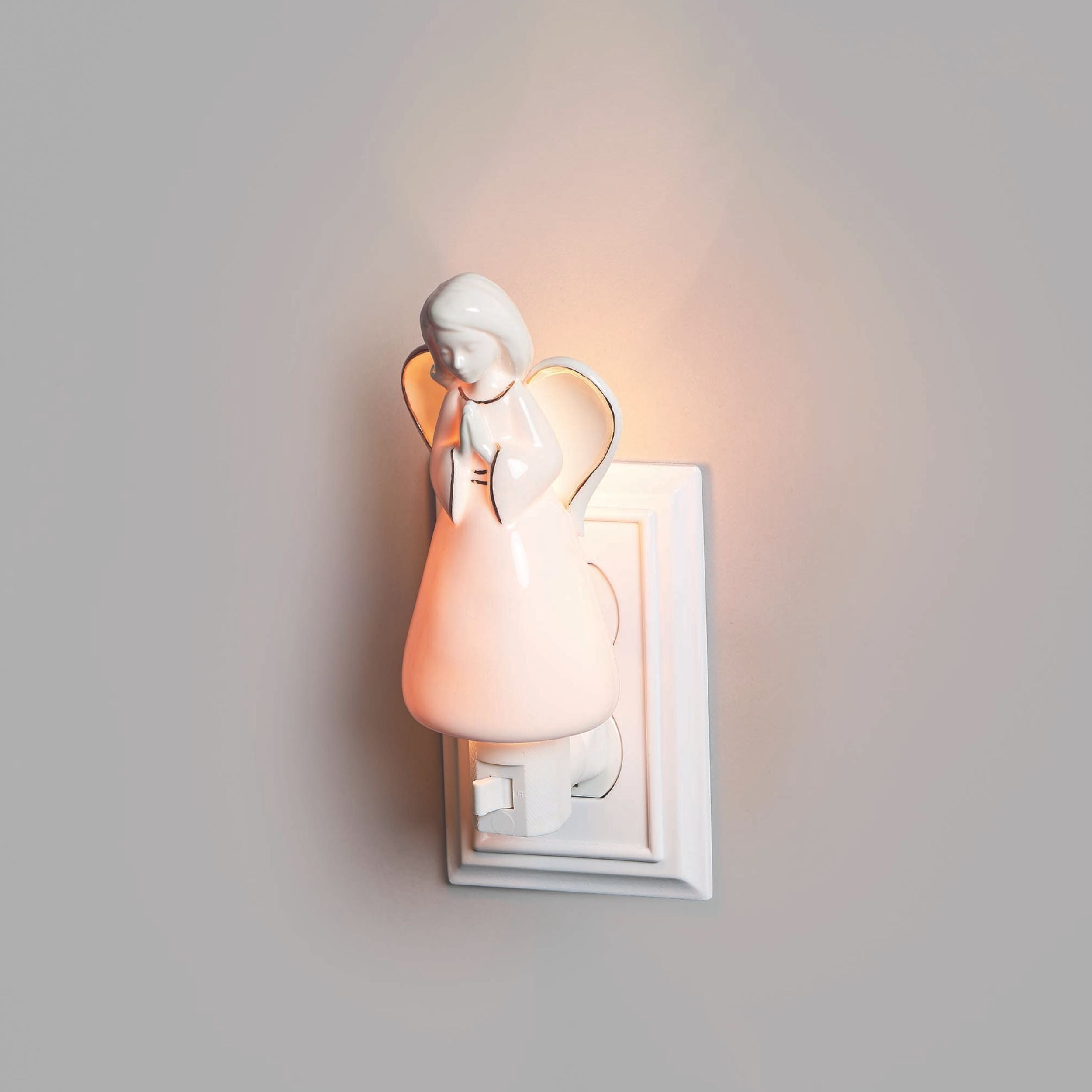 Decorative wall light shaped like an angel on a plain background