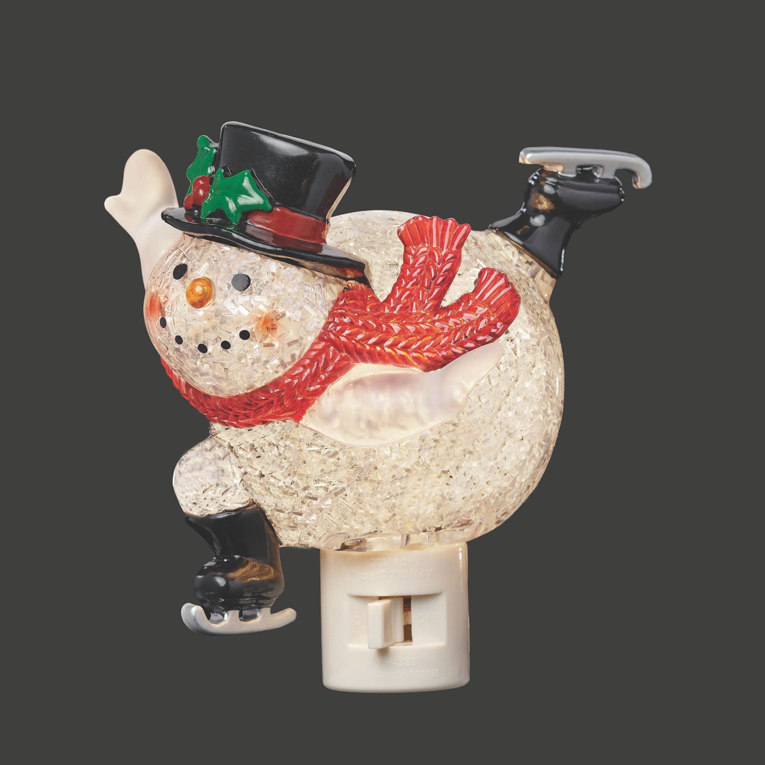 Decorative snowman night light with a black top hat and red scarf on a dark background