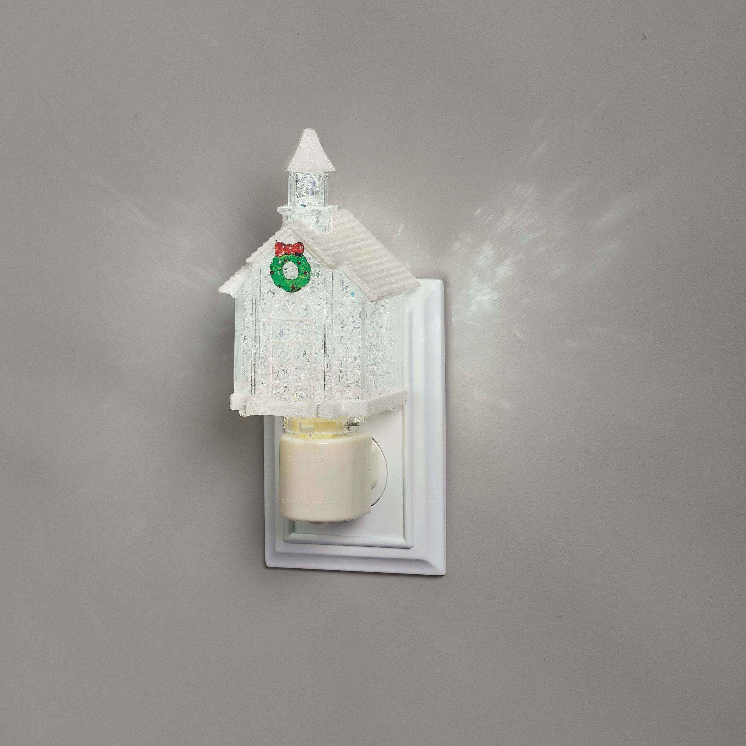 Decorative night light shaped like a small house with a candle inside on a gray background