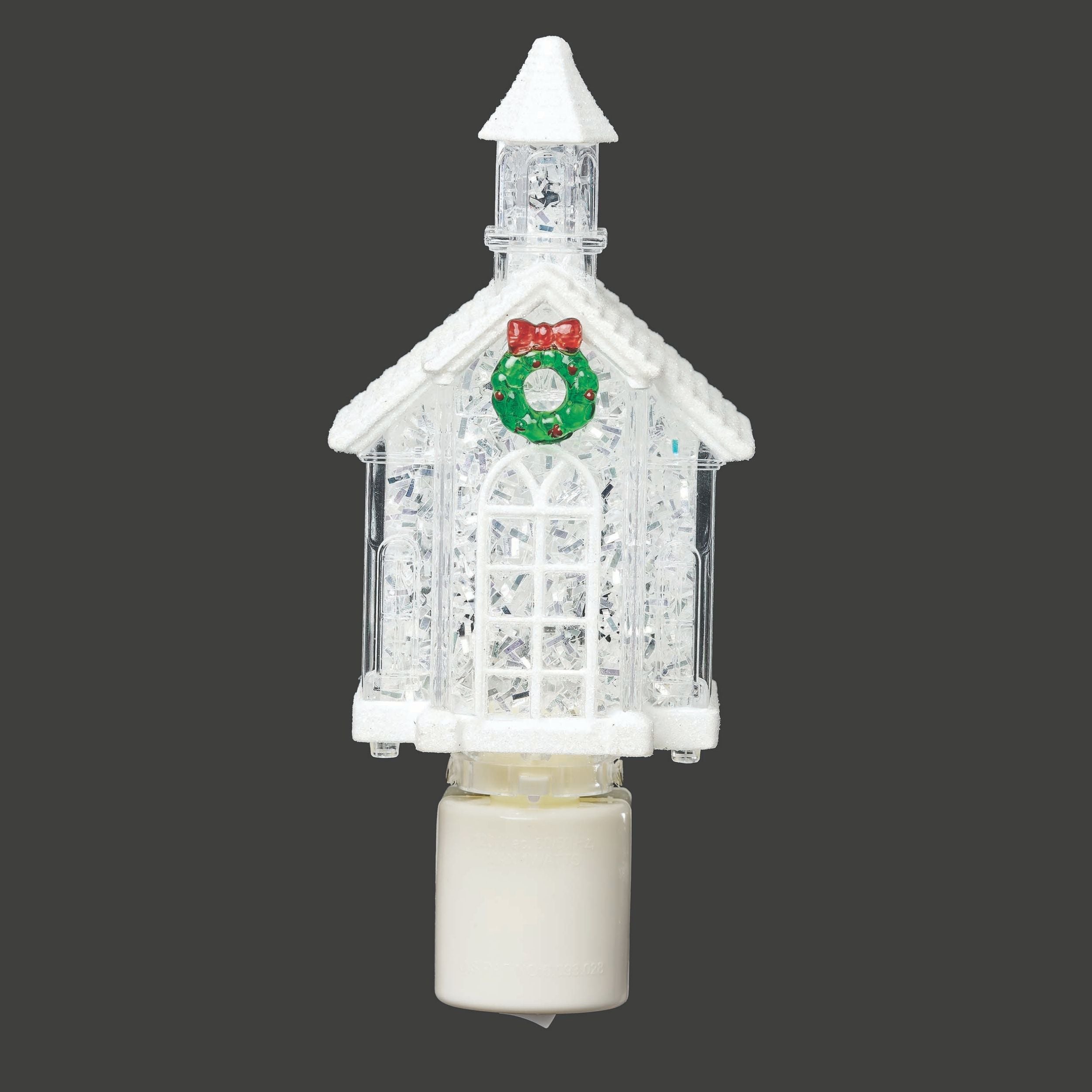 Decorative light fixture shaped like a Christmas village house with a wreath and bow on a gray background
