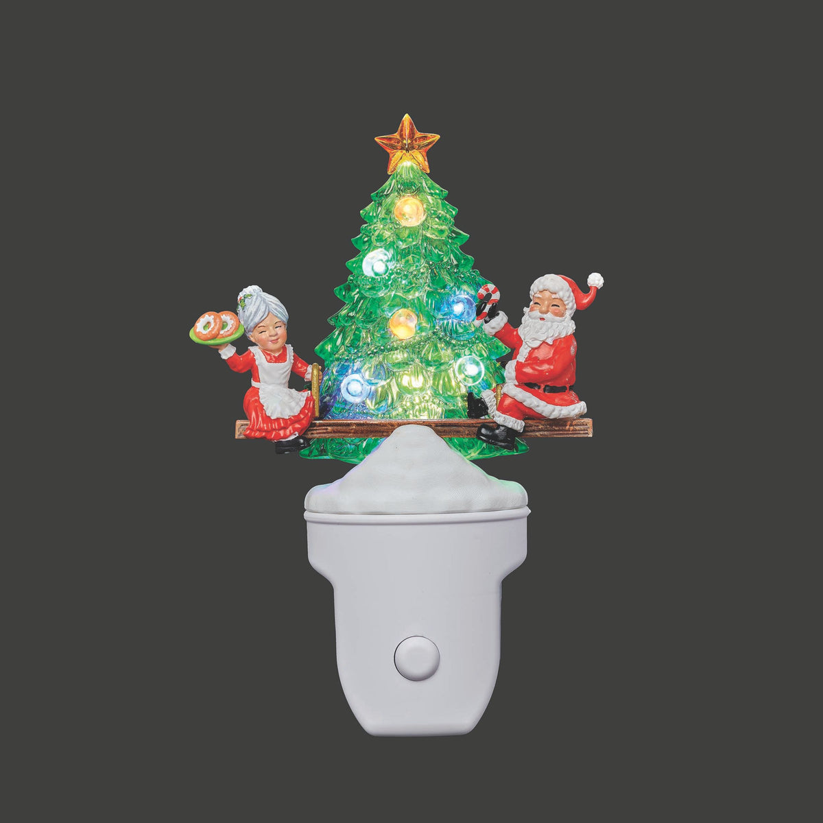 Decorative night light with Santa Claus, Mrs. Claus, and a Christmas tree on a dark background