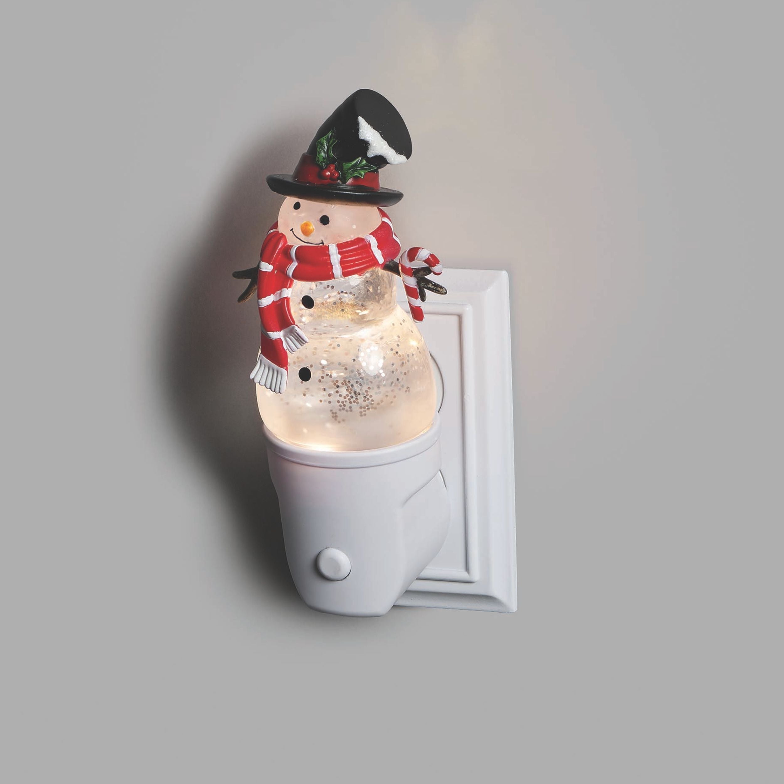 Snowman night light attached to a wall outlet on a gray background