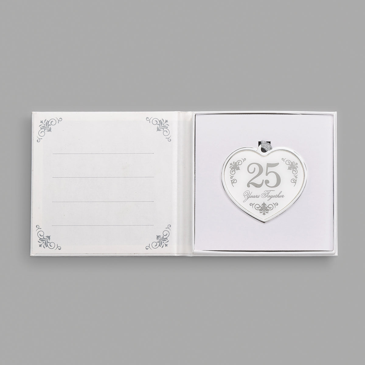 Open keepsake packaging displaying the 25th anniversary heart ornament beside a printed message.