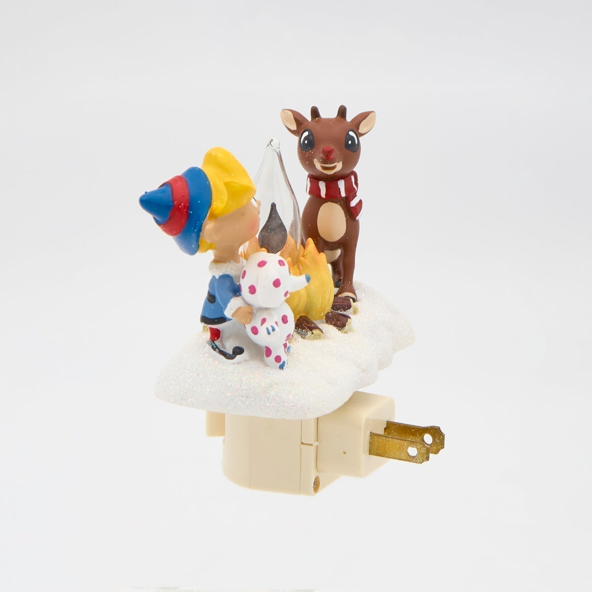 Side view of Rudolph and Hermey campfire night-light showing Hermey’s blue hat, Rudolph’s antlers, and plug prongs extending from the white base.