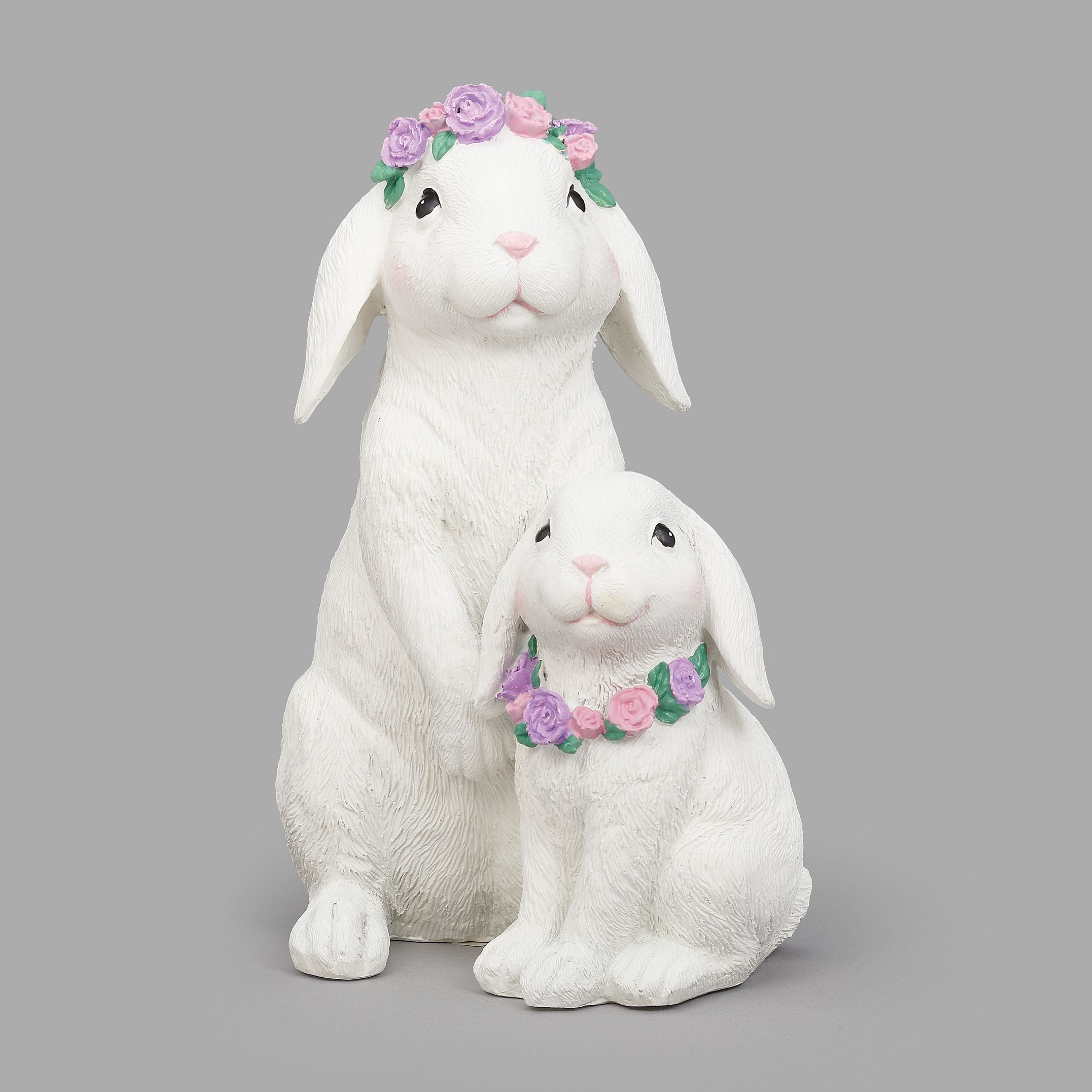 Two white rabbit figures with floral wreaths on a gray background