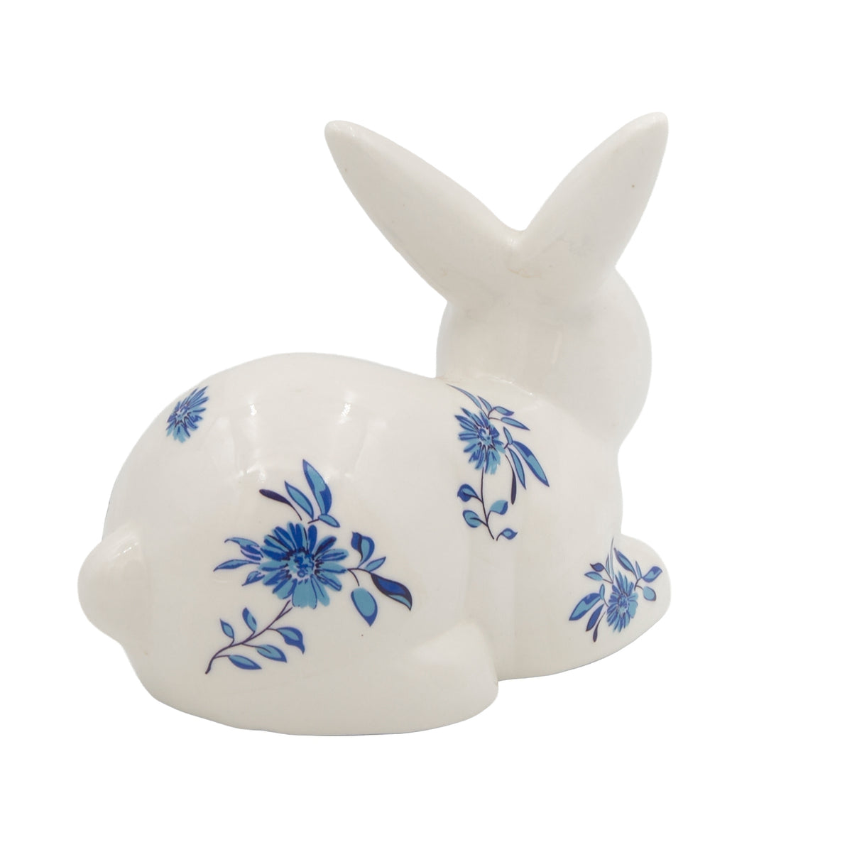 Laying Blue Willow Bunny porcelain figure with blue floral design, side view