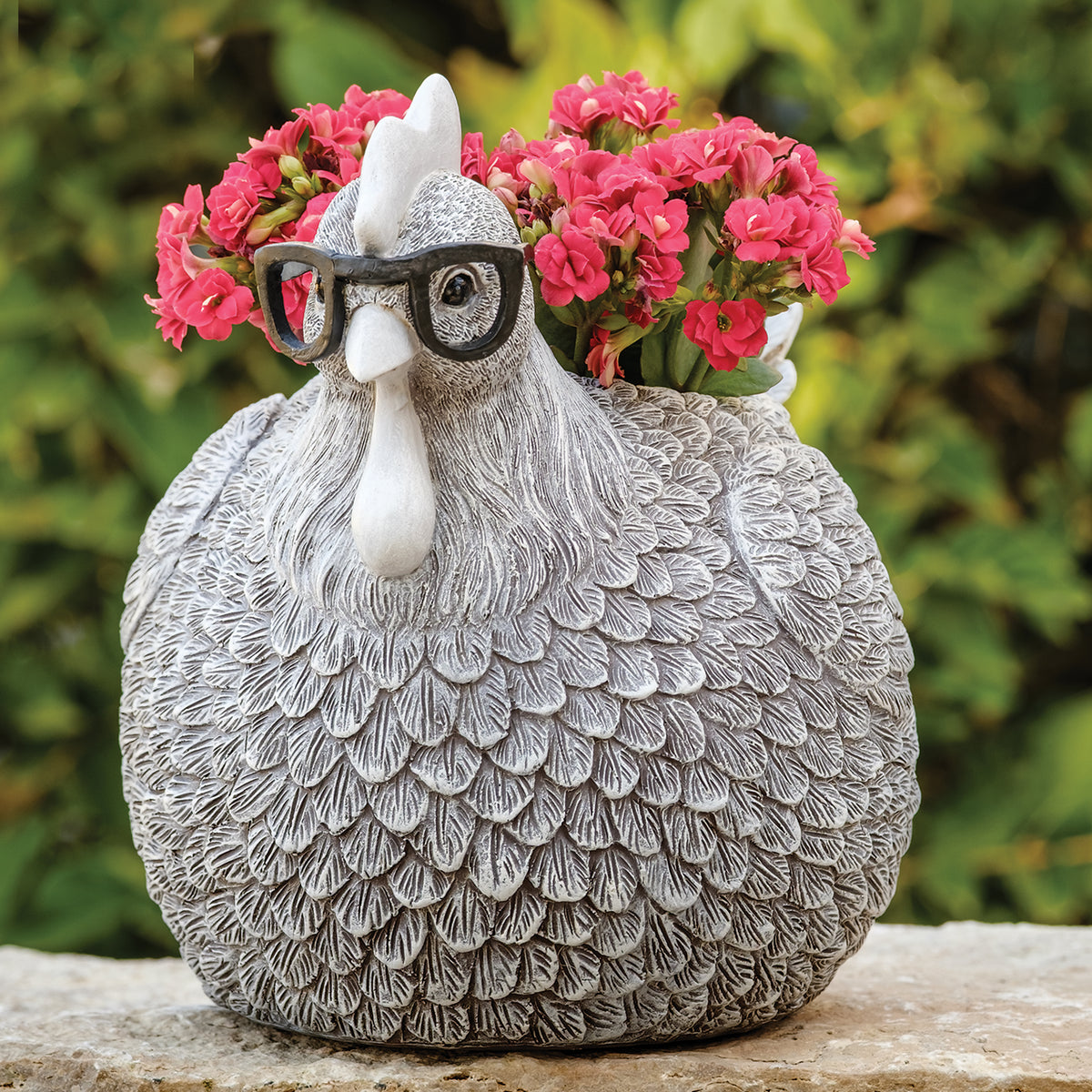 Pudgy Pals Silly Spectacles Chicken Planter with pink flowers displayed outdoors