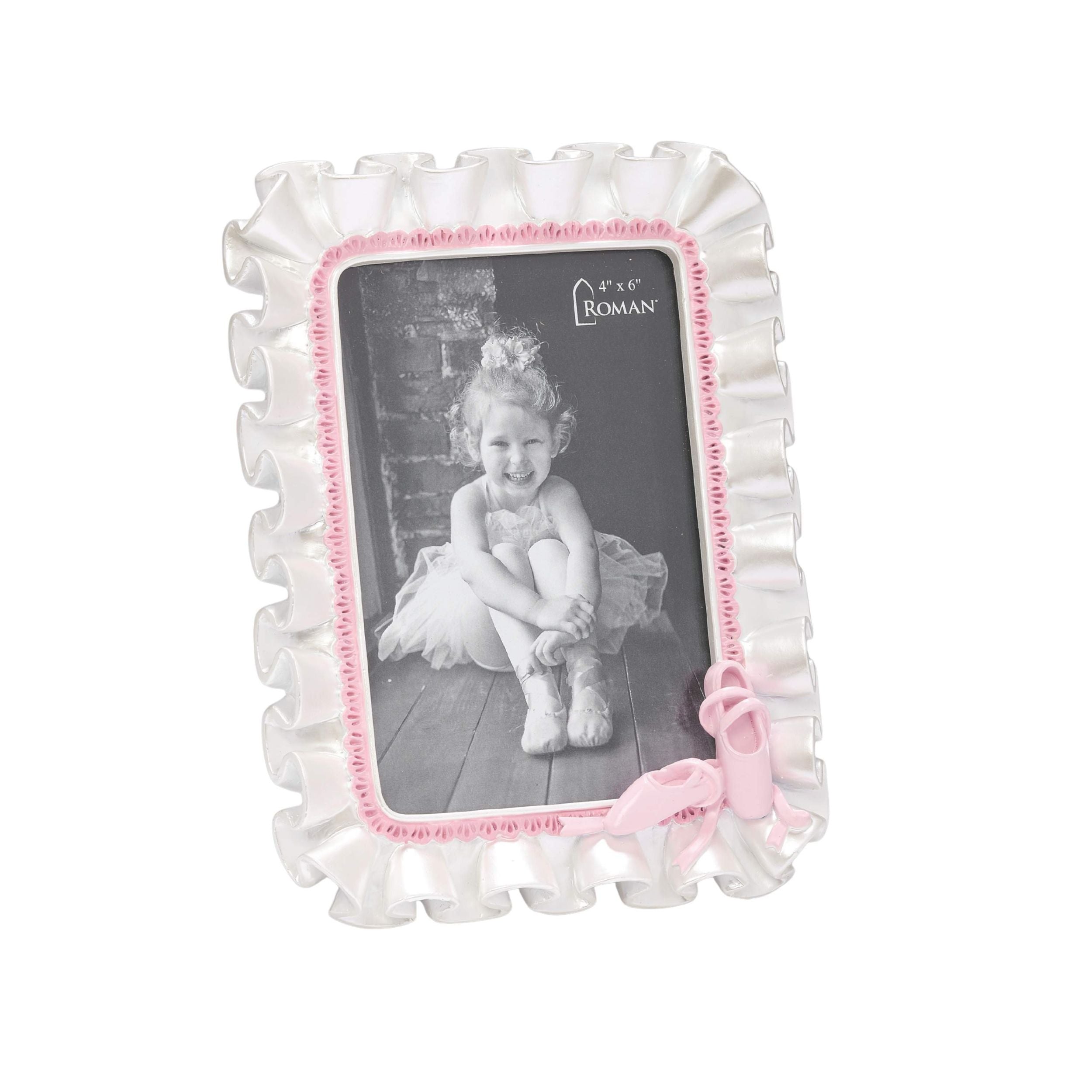 Decorative photo frame with ruffled edges and a pink bow, featuring a black and white photo of a child.