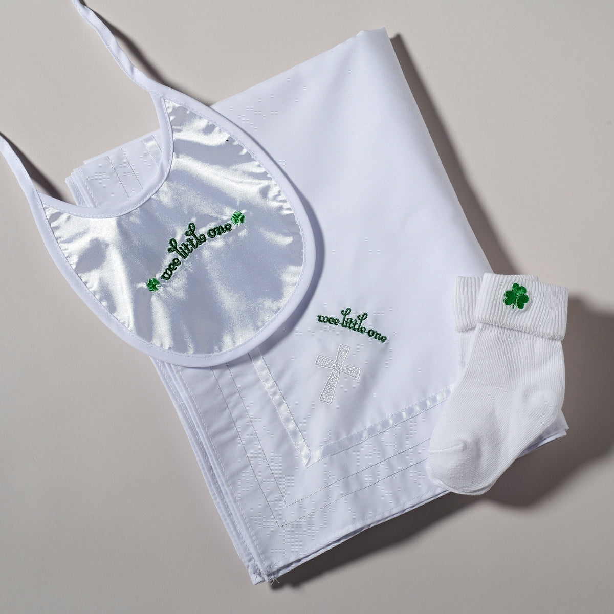 Close-up of Irish Shamrock Baptism Baby Gift Set showing the embroidered bib, blanket, and coordinating green shamrock accents