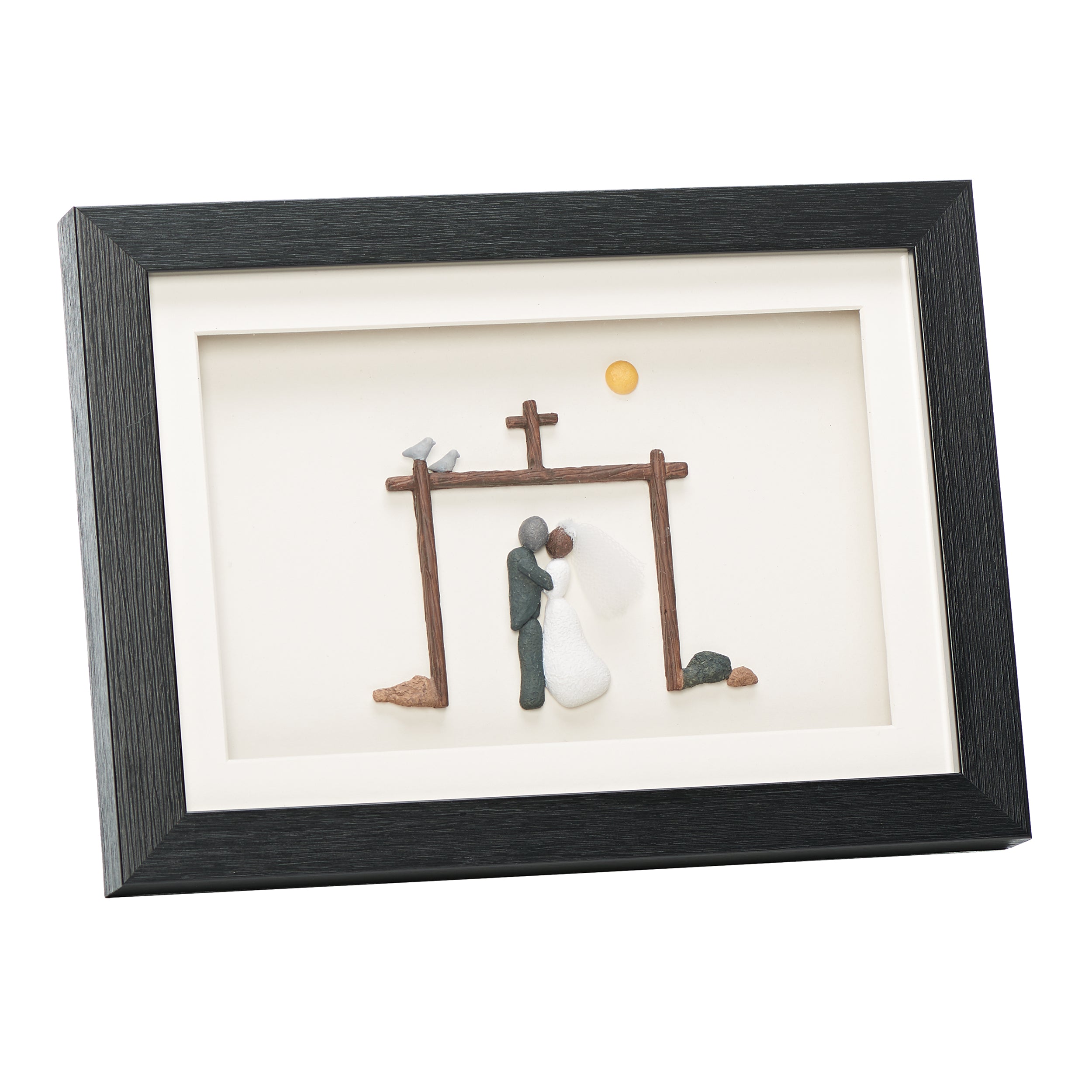 Framed artwork of a couple kissing under a cross with a black frame.