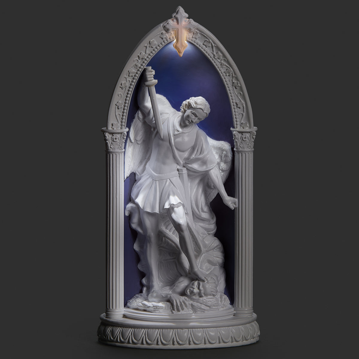 Lighted view of St. Michael in Arch plaque glowing softly around the archangel within the blue arched frame