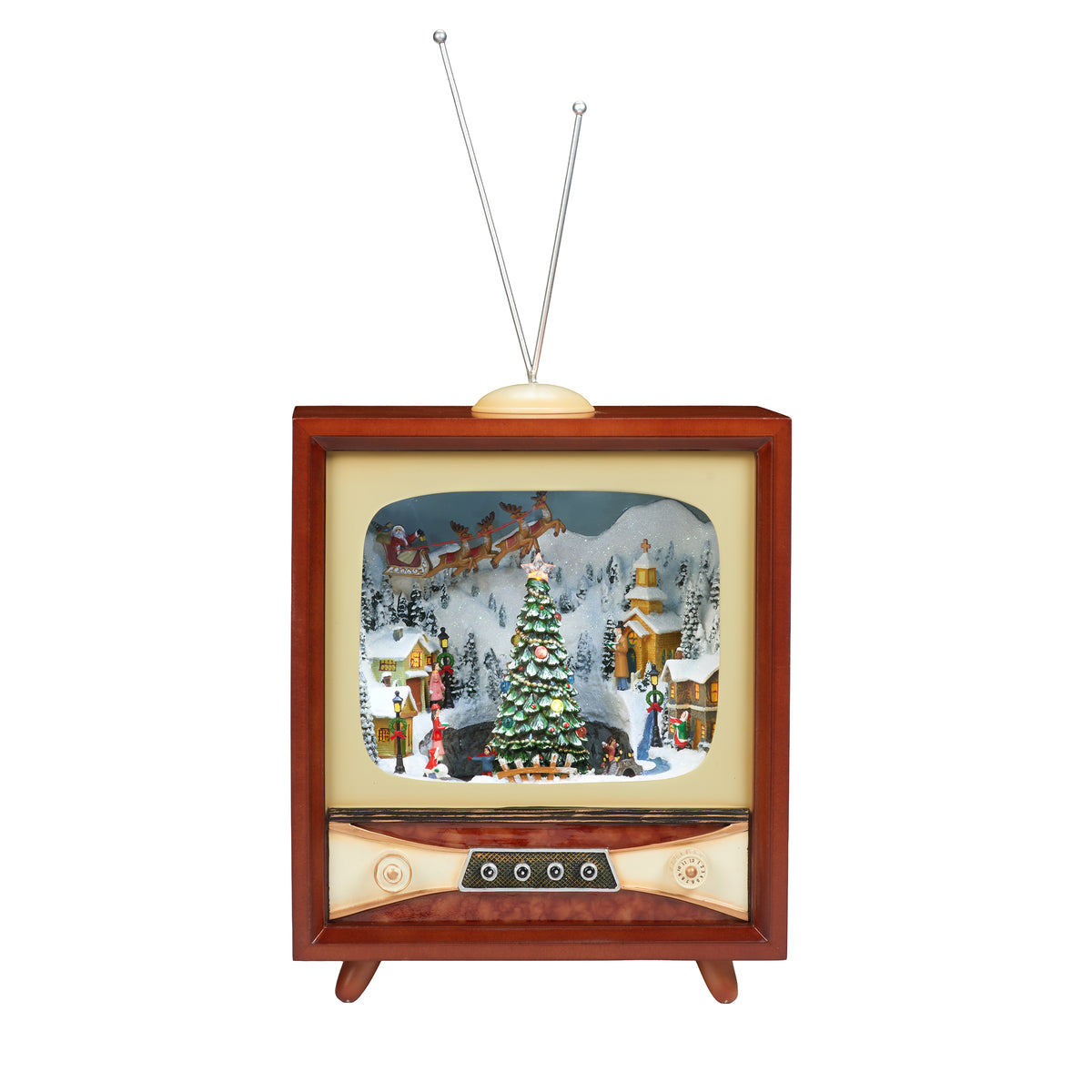 A vintage-style television figurine with a warm brown wood-grain frame, cream-colored faceplate, and silver V-shaped antennas. The screen displays a detailed Christmas diorama with a decorated tree, snowy mountains, and a sleigh scene.