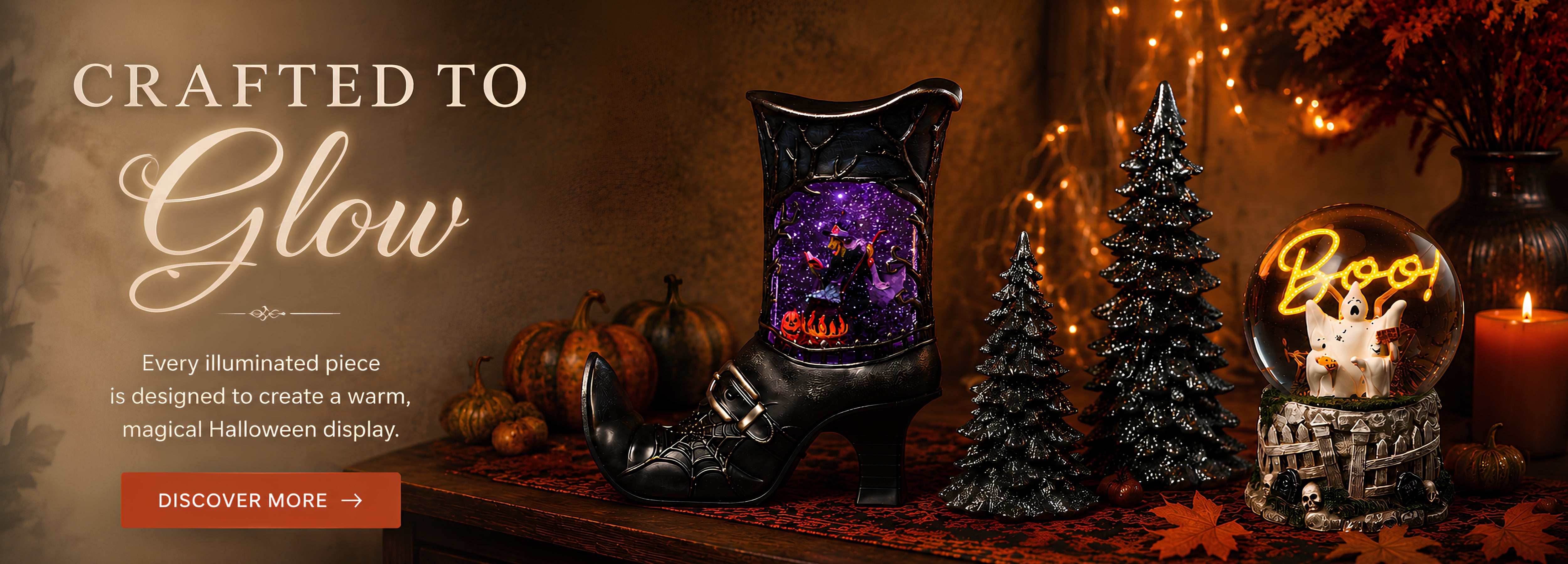 Halloween-themed promotional banner featuring a black witch's boot decorative piece with a glowing purple and orange interior, displayed beside a glowing 'Boo!' glitterdome, small black Christmas trees, pumpkins, and warm string lights. Large text reads 'Crafted to Glow' with a 'Discover More' button.