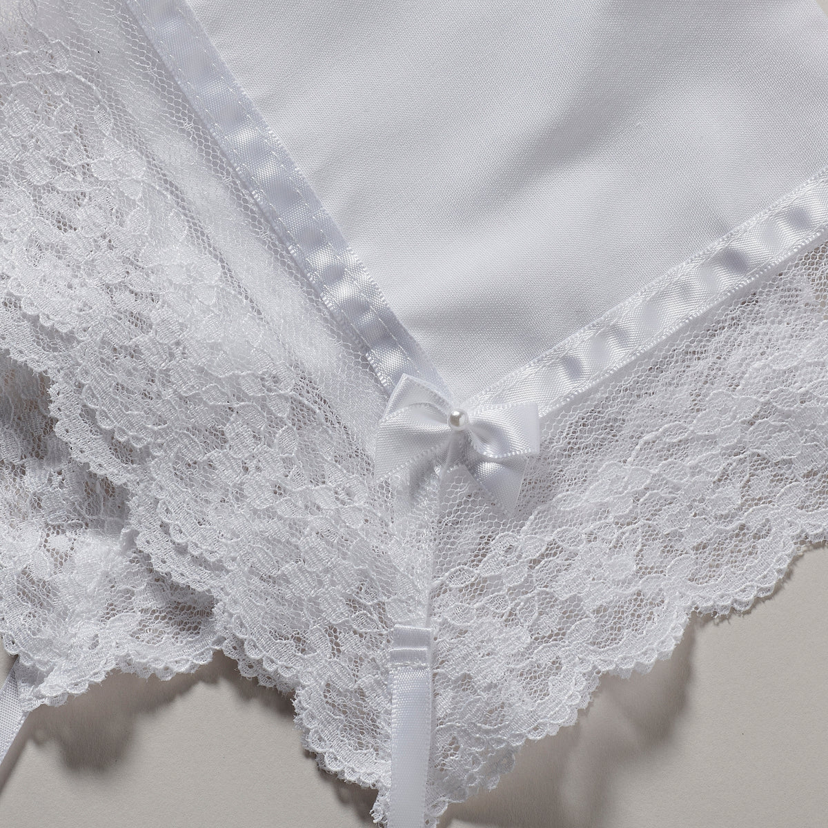 Close-up of Baby’s First Bonnet showing the intricate white lace trim and embroidered fabric details