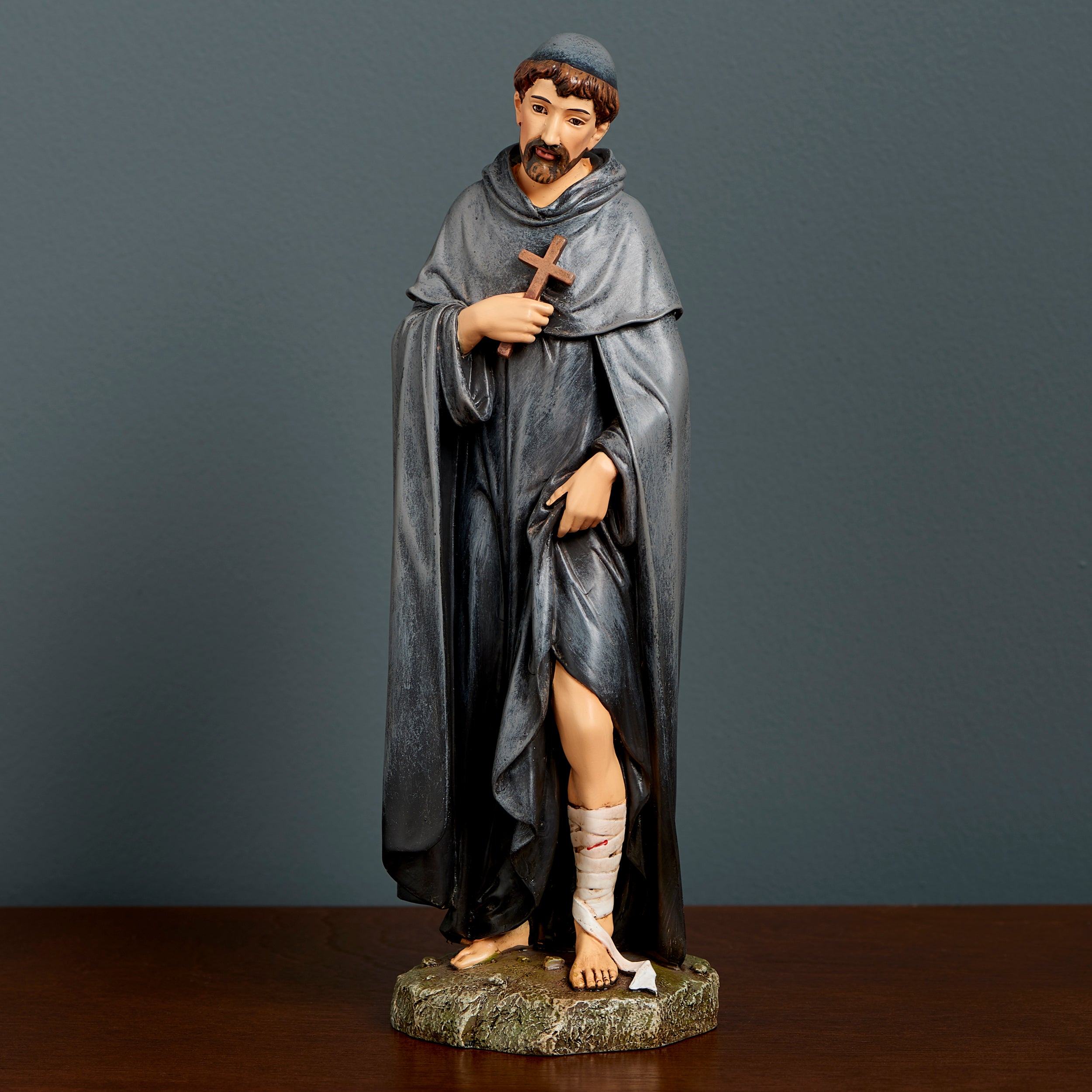 Statue of a monk with a cross on a dark background
