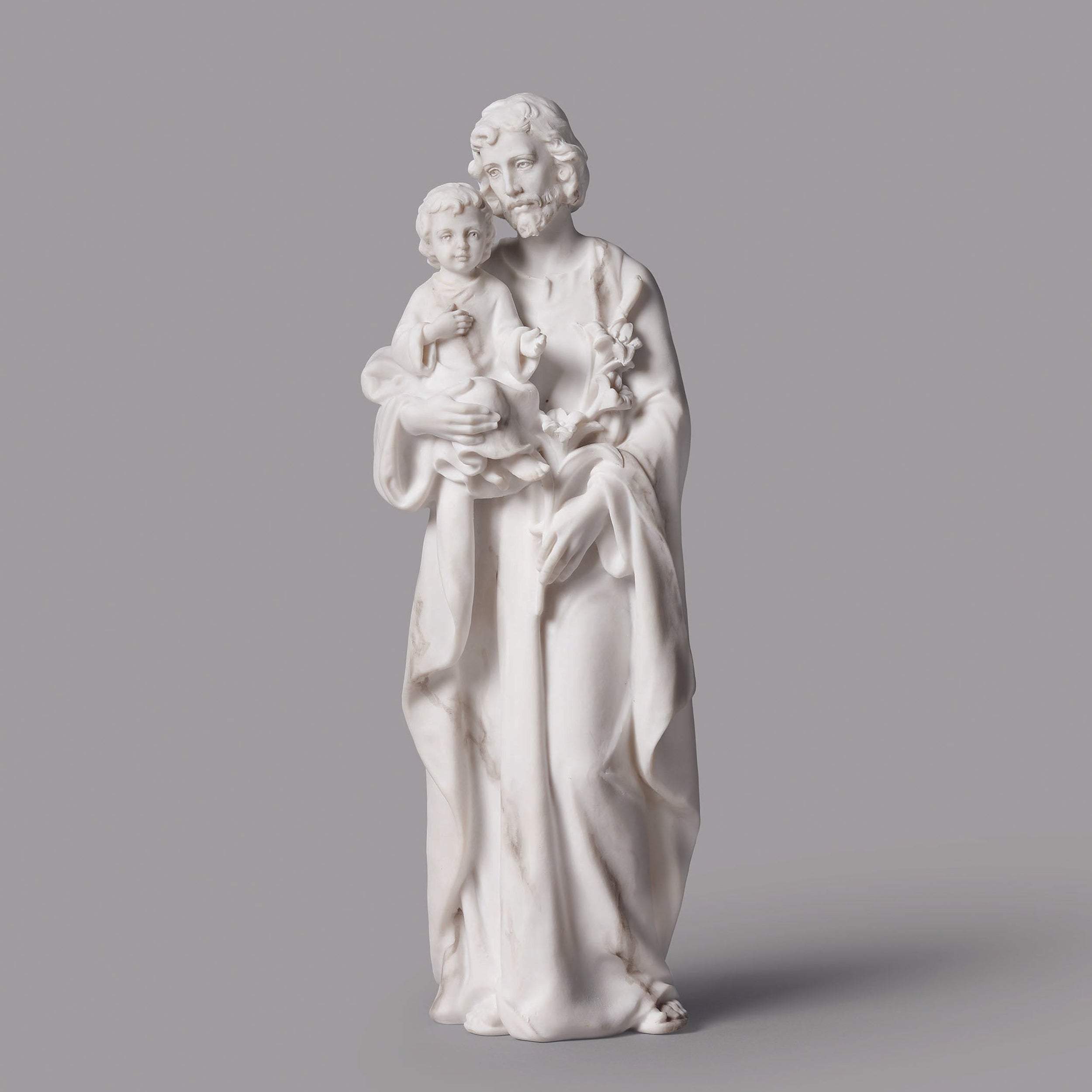 White marble statue of a woman holding a child on a gray background