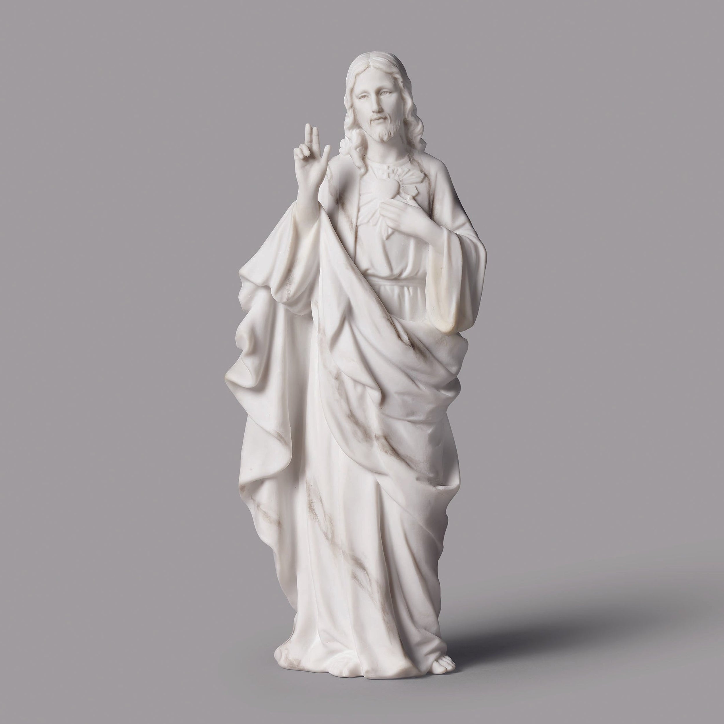 White statue of a religious figure on a gray background