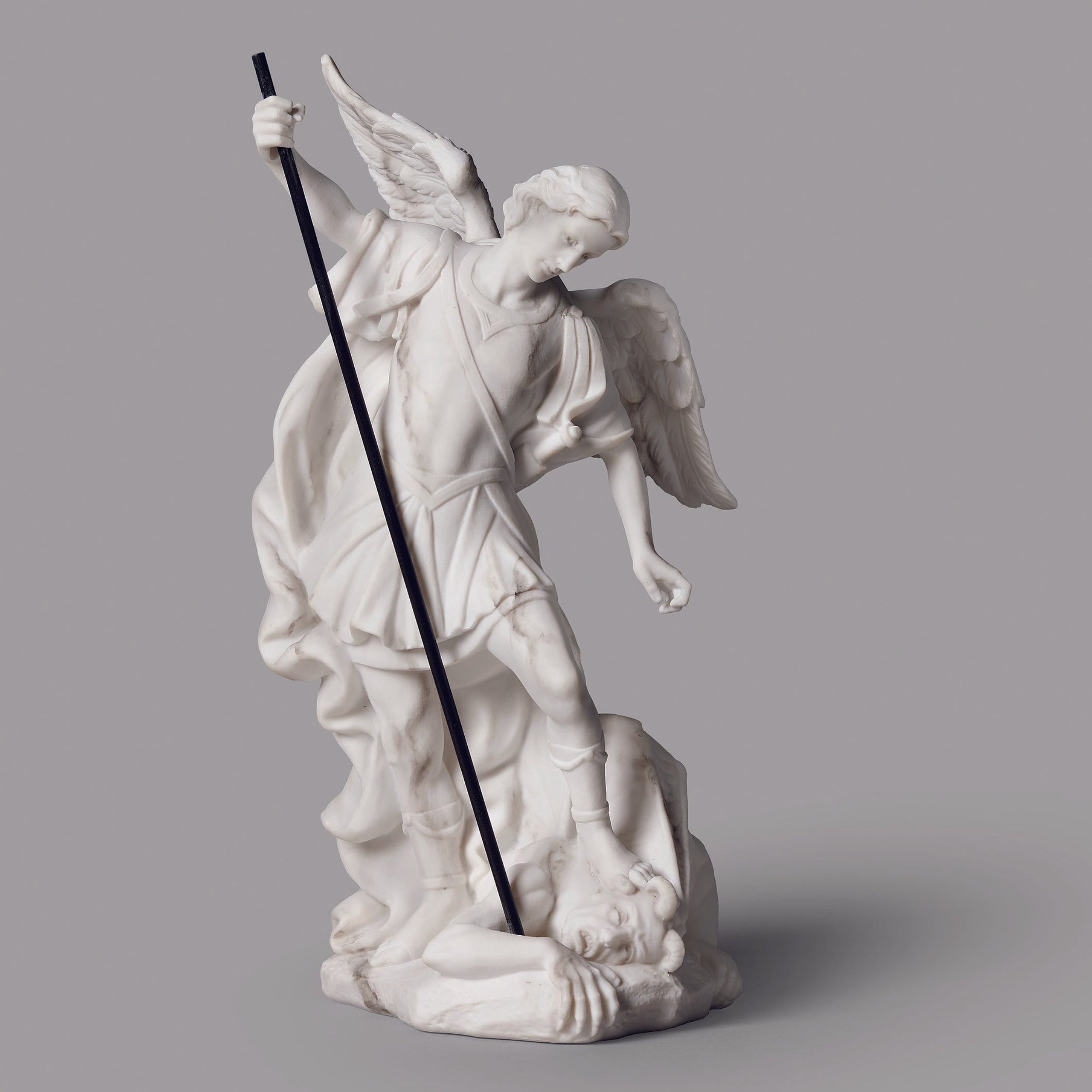 White angel statue with a sword on a gray background