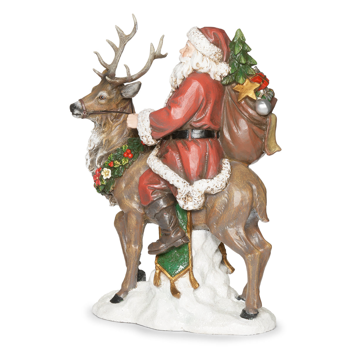 Side angled view of Joseph's Studio Santa Riding Deer Figure showing Santa's gift-filled sack, red suit, and the decorated deer on a snowy base