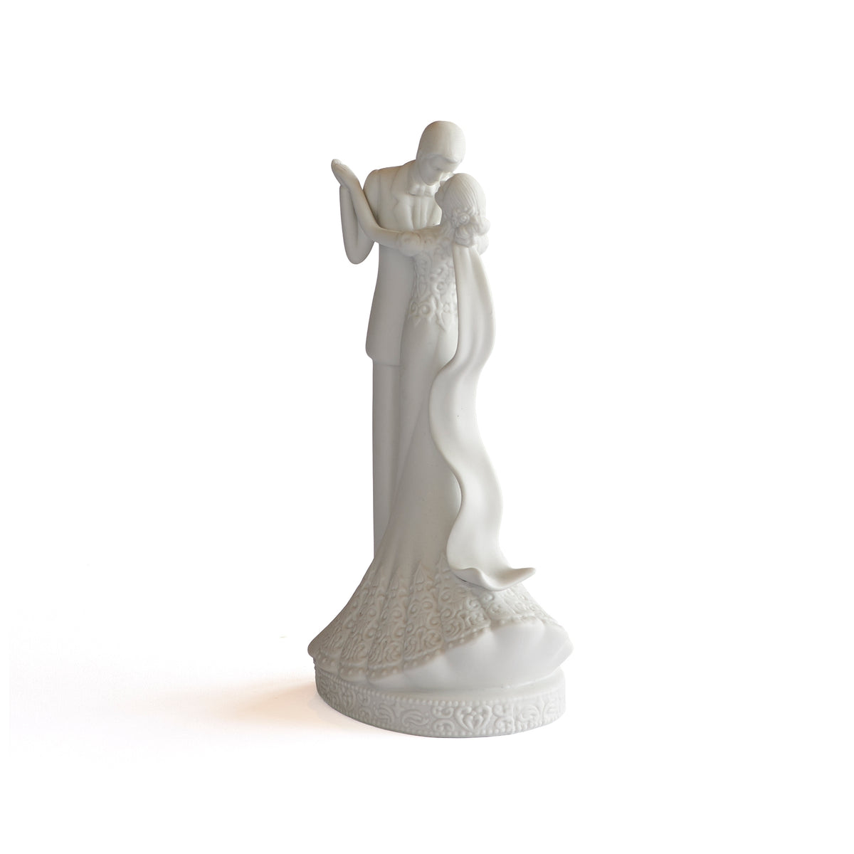 Angled view of wedding cake topper highlighting the bride’s patterned skirt and sweeping veil.