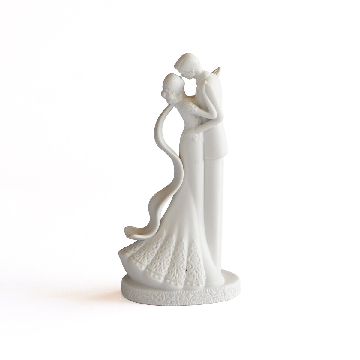 Opposite side view of porcelain couple showing the curved veil flowing behind the bride.