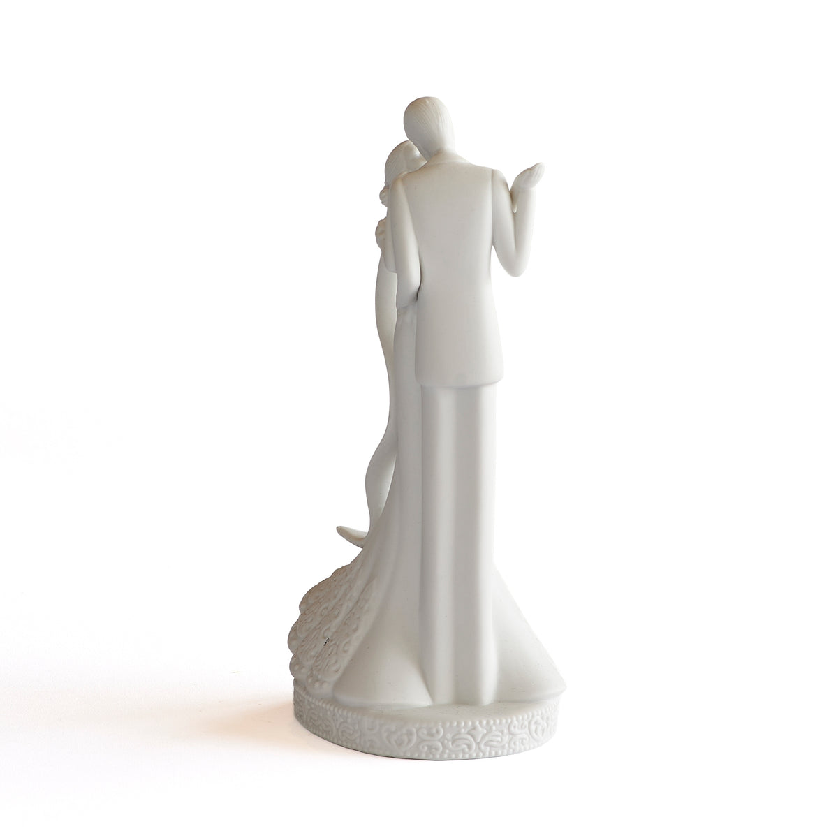 Rear view of wedding cake topper showing the groom’s suit and the bride’s long gown.