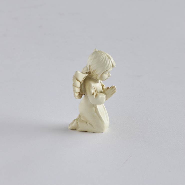 Opposite side view of kneeling angel showing its bowed head, clasped hands, and prayerful pose.