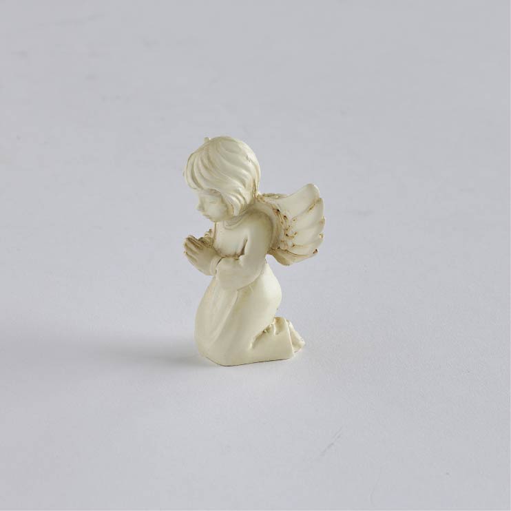 Side view of Worry Angel showing its feathered wing and flowing cream gown.