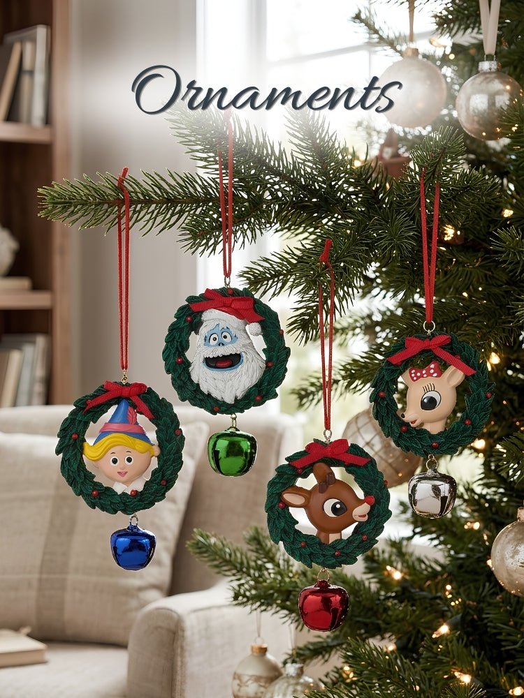 Four handmade Christmas ornaments hanging on a decorated Christmas tree in a cozy living room setting. The ornaments are circular green wreaths featuring cartoon characters: a Santa Claus face, a girl with a party hat, a reindeer, and a reindeer with a bow, each with a small hanging bell below.