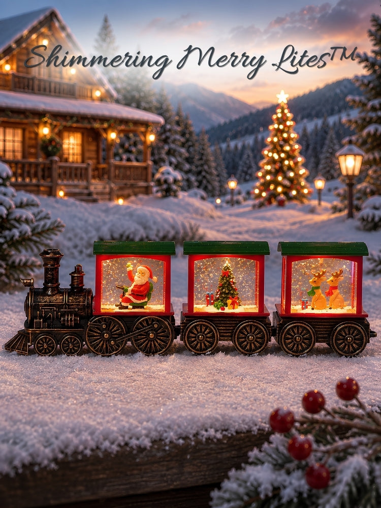 A festive Christmas snow globe train decoration displayed outdoors in a snowy landscape with a cabin, mountains, and a lit Christmas tree in the background. The train has three glowing red and green snow globe carriages with miniature holiday scenes inside, and the text 'Shimmering Merry Lites' is written at the top.