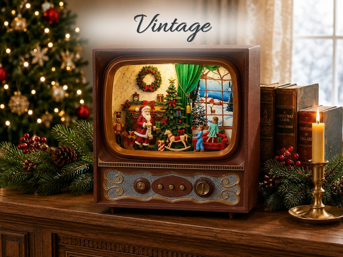 A vintage-style wooden television set with a lit Christmas diorama scene inside, placed on a wooden mantel with holiday greenery, books, a candle, and a blurred Christmas tree in the background. The word 'Vintage' appears above the TV.